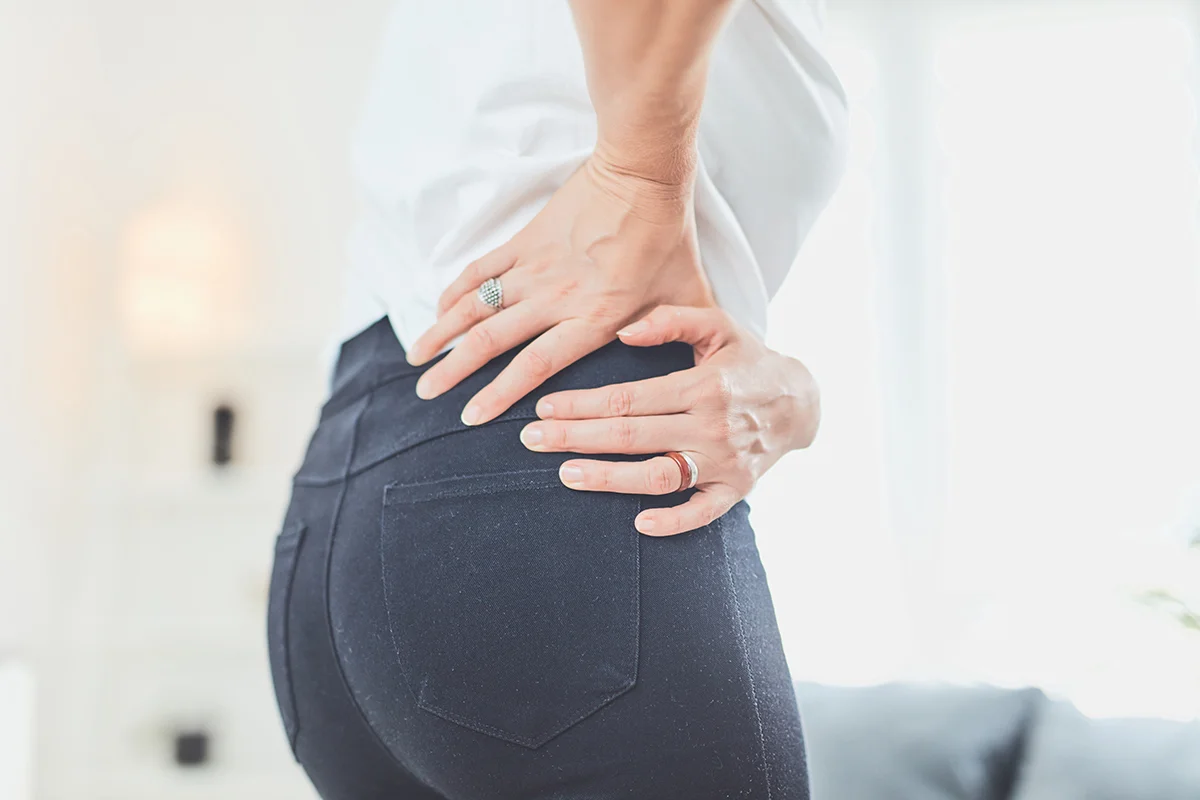 woman holding lower back inside 1